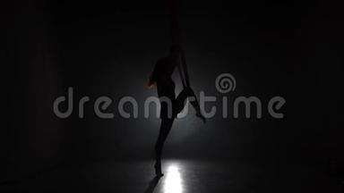在马戏团舞台上表演红绸的女空中体操运动员。 精彩的杂技表演..